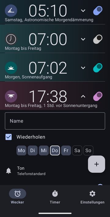Eine geöffnete Weckerkarte für 17:38, von Montag bis Freitag, 1 Std. vor Sonnenuntergang: ein leeres Feld Name, das Kontrollkästchen Wiederholen angekreuzt mit den Tagen Mo bis Fr ausgewählt (Sa und So nicht), und Ton auf Telefonstandard. Die Karte setzt sich unter dem Bildrand fort.