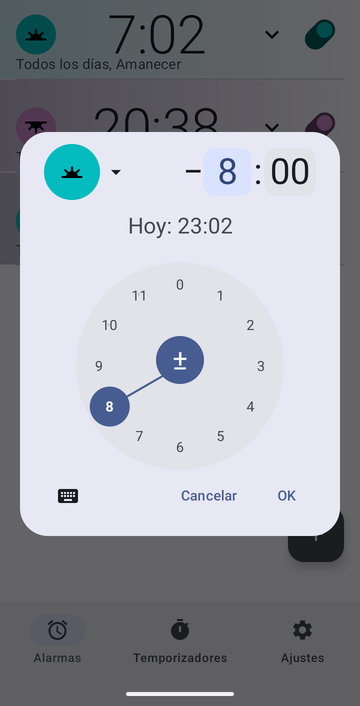 El cuadro de creación de alarma configurado en Amanecer con un desplazamiento de menos 8 horas y 00 minutos, el disco de las horas en 8, y la línea Hoy: 23:02.
