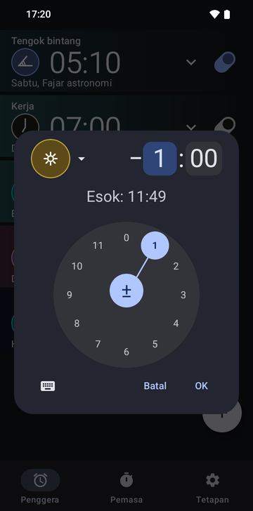 Dialog cipta penggera Risetime terbuka di atas senarai penggera: ikon sauh Noon berwarna emas, anjakan minus 1 hour dan 00 minutes dengan medan jam dipilih, dan baris Tomorrow: 11:49. Dail jam bulat dengan 1 dipilih memenuhi separuh bawah, dengan butang papan kekunci, Cancel dan OK di bawahnya.