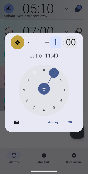 Okno tworzenia alarmu Risetime, otwarte nad listą: pigułka kotwicy Południe, przesunięcie minus 1 godzina i 00 minut z zaznaczonym polem godzin, oraz wiersz Jutro: 11:49. Okrągła tarcza godzin z zaznaczoną 1 zajmuje dolną połowę, z Anuluj i OK poniżej.